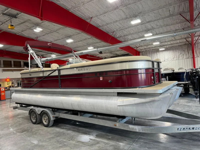 Slide: The Image of 2016 Crest 250 pontoon boat on trailer in indoor storage facility. - 2