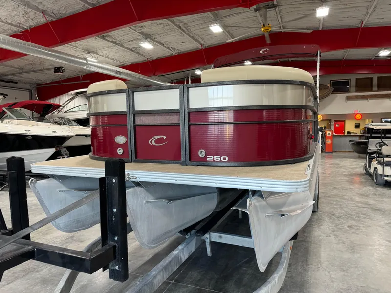 Slide: The Image of 2016 Crest 250 pontoon boat in showroom, red and beige design, on trailer. - 5