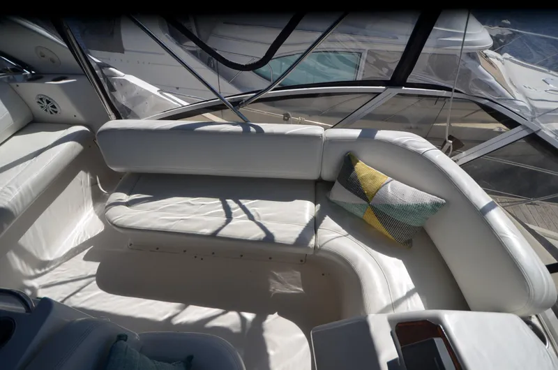 Slide: The Image of 2000 Silverton 330 Sport Bridge interior with white seating and decorative pillows. - 10