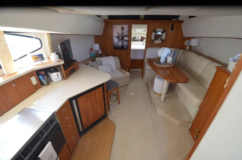 Slide: The Image of Interior of 2000 Silverton 330 Sport Bridge yacht with kitchen and seating area. - 13