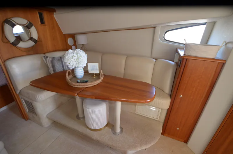 Slide: The Image of Interior of 2000 Silverton 330 Sport Bridge with cozy seating and wooden table. - 14