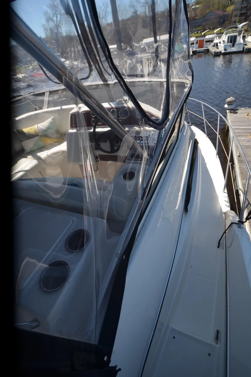 Slide: The Image of 2000 Silverton 330 Sport Bridge yacht with clear canopy and dockside view. - 24