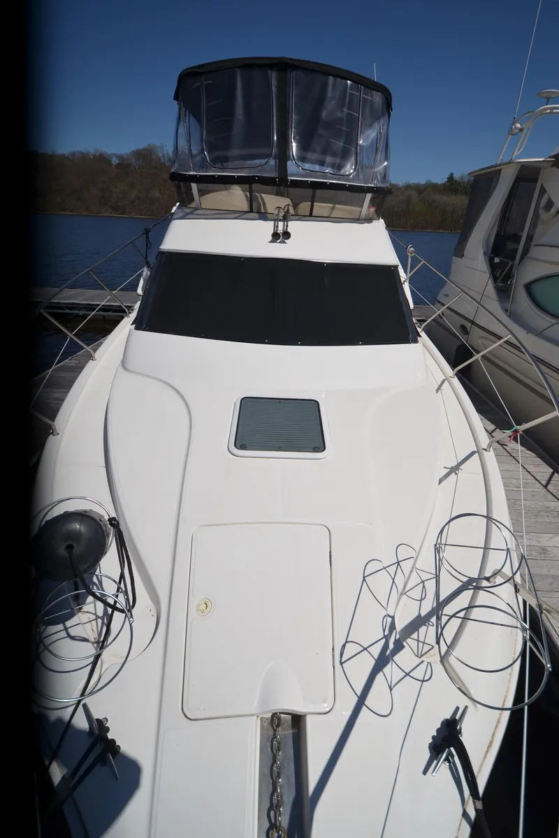 Slide: The Image of 2000 Silverton 330 Sport Bridge yacht docked, featuring sleek design and spacious deck. - 25