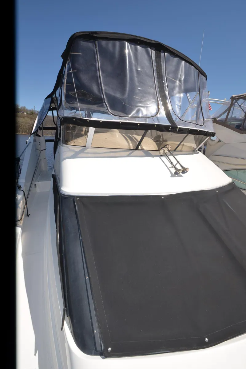 Slide: The Image of 2000 Silverton 330 Sport Bridge with black canopy and sleek design. - 26