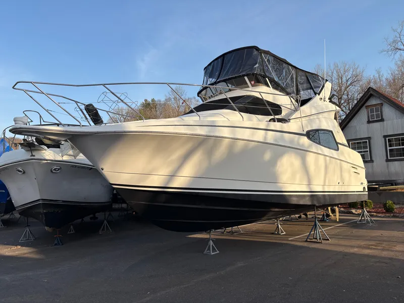 Slide: The Image of 2000 Silverton 330 Sport Bridge yacht on stands, parked outdoors near a building. - 28