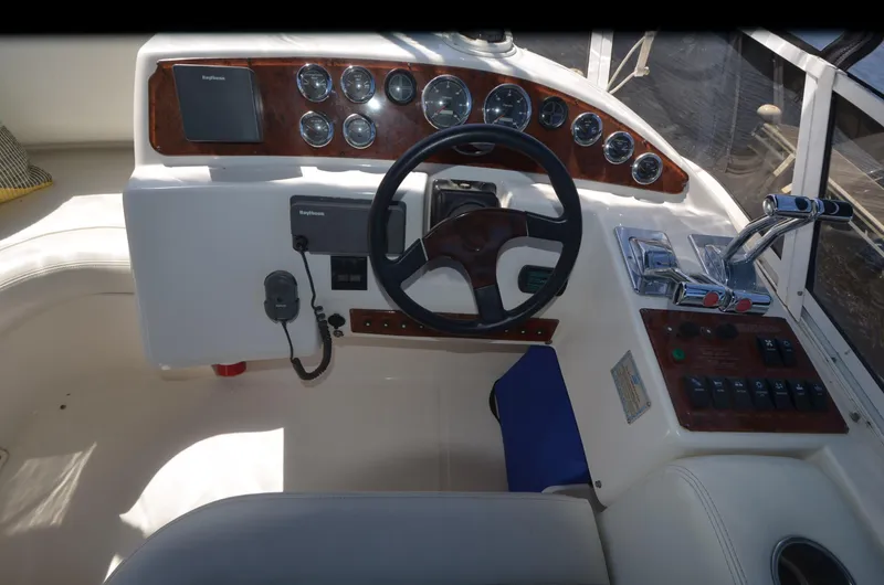 Slide: The Image of Cockpit of 2000 Silverton 330 Sport Bridge with steering wheel and control panel. - 8