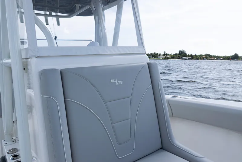 Slide: The Image of 2024 SeaVee 290B boat interior with gray seating, on a calm ocean backdrop. - 15