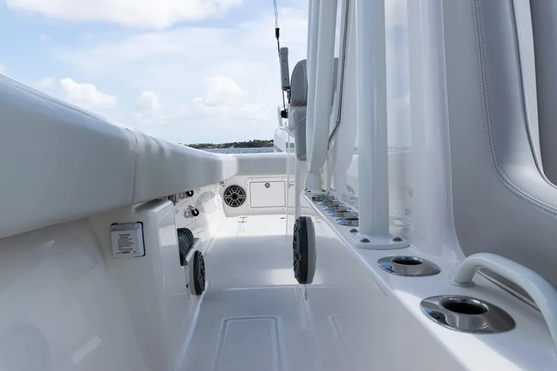 Slide: The Image of 2024 SeaVee 290B boat deck with rod holders and seating, under a clear sky. - 17
