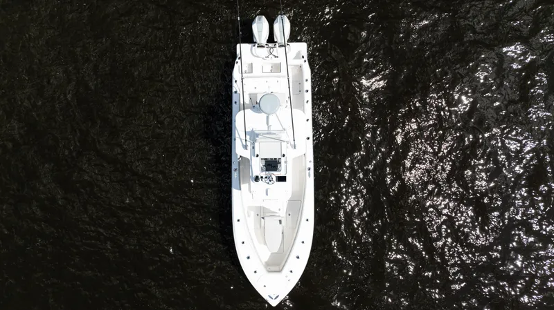 Slide: The Image of 2024 SeaVee 290B boat on calm water under a partly cloudy sky. - 2
