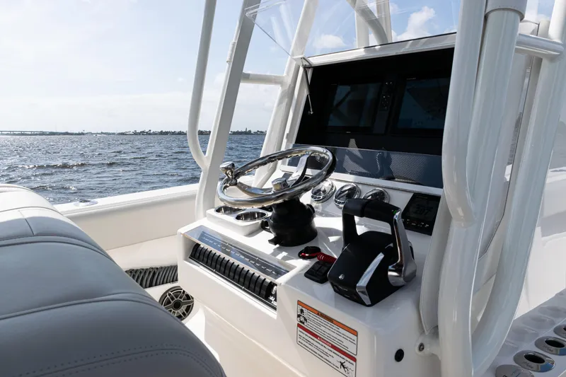 Slide: The Image of 2024 SeaVee 290B boat console with steering wheel and controls, on open water. - 21