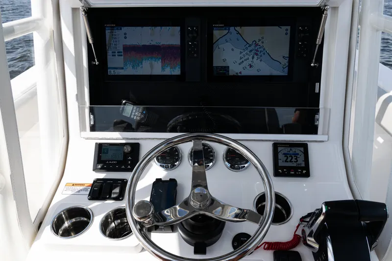 Slide: The Image of 2024 SeaVee 290B helm with dual displays, steering wheel, and navigation controls. - 22