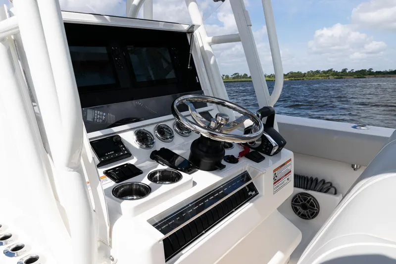 Slide: The Image of 2024 SeaVee 290B boat console with steering wheel and controls on open water. - 23