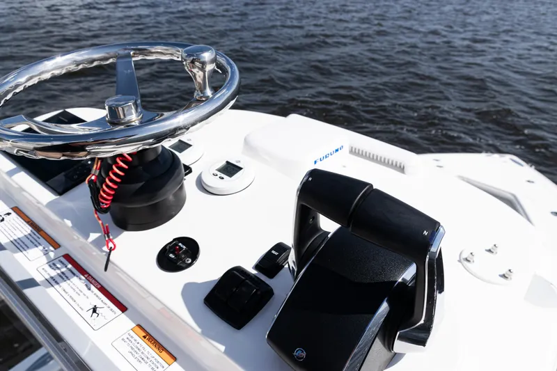 Slide: The Image of 2024 SeaVee 290B boat helm with steering wheel and controls on water. - 36