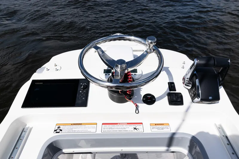 Slide: The Image of 2024 SeaVee 290B boat helm with steering wheel and controls on water. - 38