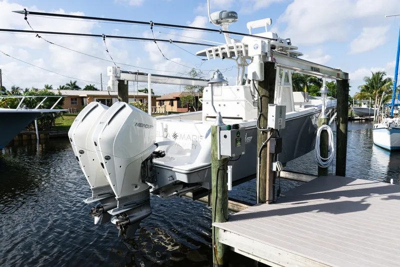 Slide: The Image of 2024 SeaVee 290B boat with dual Mercury engines docked on a lift. - 45
