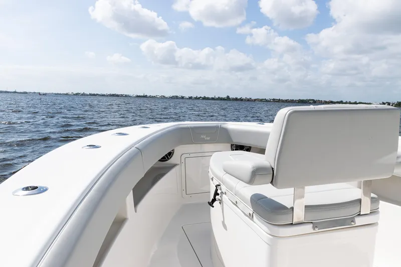 Slide: The Image of 2024 SeaVee 290B boat, white seating, ocean view, partly cloudy sky. - 7