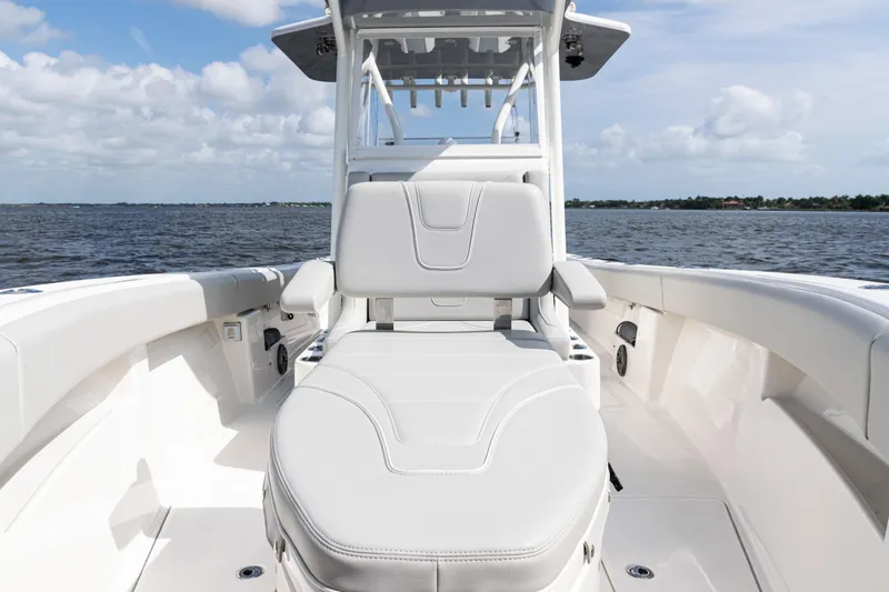 Slide: The Image of 2024 SeaVee 290B boat interior with cushioned seating, ocean view, and clear sky. - 9