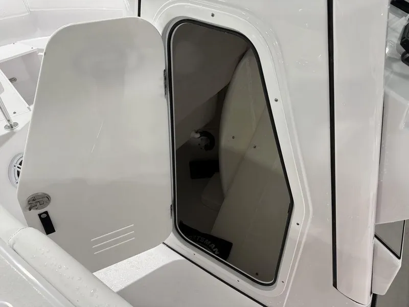 Slide: The Image of 2025 Sportsman Open 212 boat storage compartment with open door, showcasing interior space. - 10