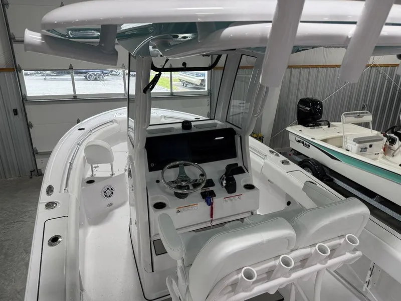 Slide: The Image of 2025 Sportsman Open 212 boat interior with steering console and seating in a garage. - 13