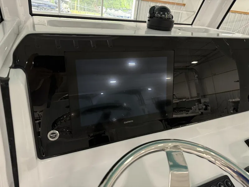 Slide: The Image of 2025 Sportsman Open 212 boat dashboard with Garmin display and compass. - 17