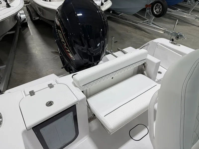 Slide: The Image of 2025 Sportsman Open 212 boat interior with seating and outboard motor in showroom. - 24