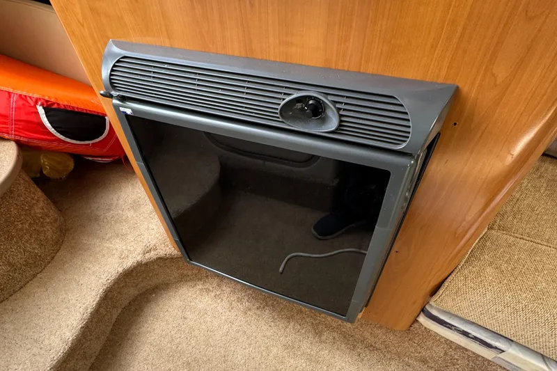 Slide: The Image of 2002 Bayliner 2455 Ciera cabin interior with compact black refrigerator. - 12