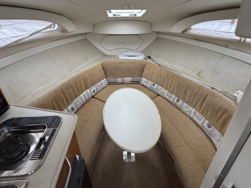 Slide: The Image of Interior of a 2002 Bayliner 2455 Ciera boat with cozy seating and table. - 25