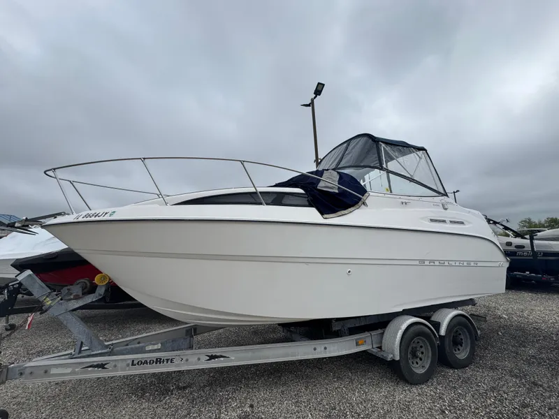 Slide: The Image of 2002 Bayliner 2455 Ciera boat on trailer, parked outdoors under cloudy sky. - 42