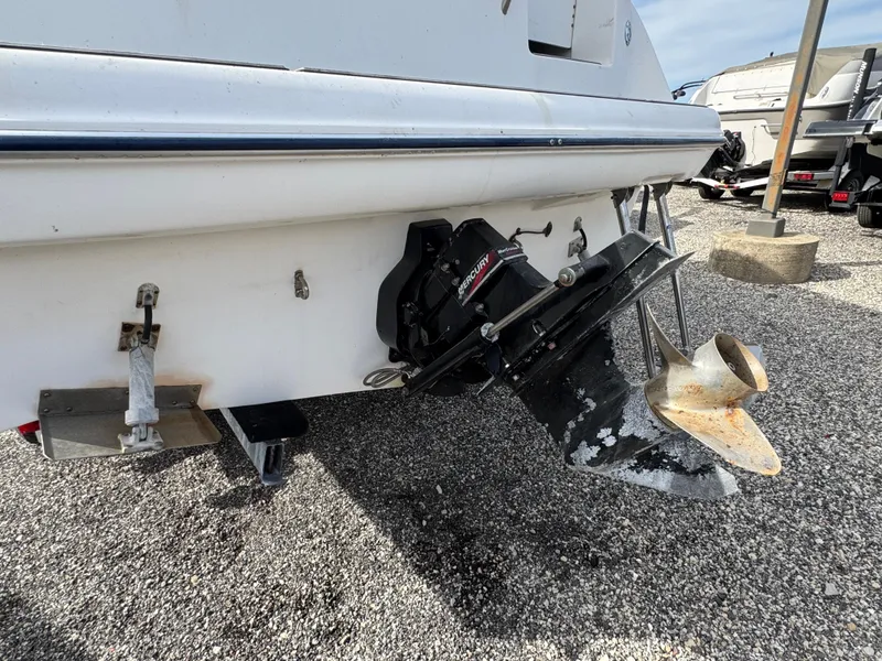Slide: The Image of Bayliner 2455 Ciera 2002 boat stern with outboard motor on gravel. - 9