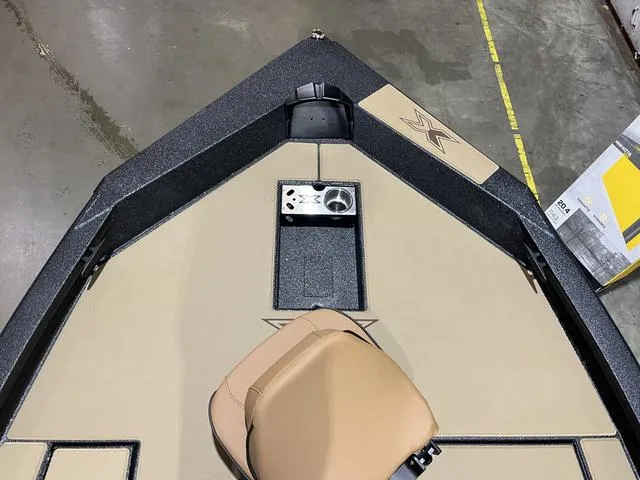 Slide: The Image of 2025 Xpress Hyper-Lift Bass H18 boat interior with tan seating and control panel. - 12