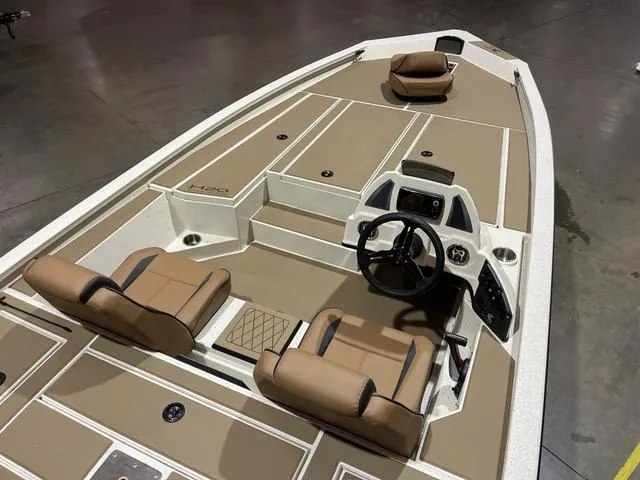 Slide: The Image of 2025 Xpress Hyper-Lift Bass H20 boat interior with tan seating and steering console. - 8