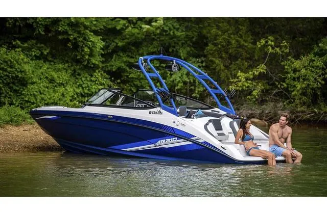 Slide: The Image of 2020 Yamaha AR210 boat with two people relaxing by the water. - 26