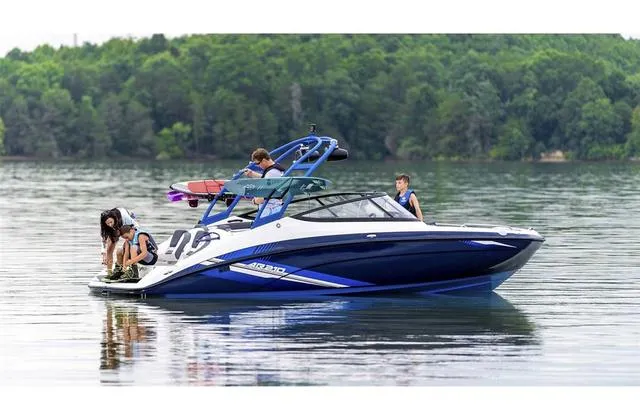 Slide: The Image of 2020 Yamaha AR210 boat on a calm lake with people enjoying water activities. - 28