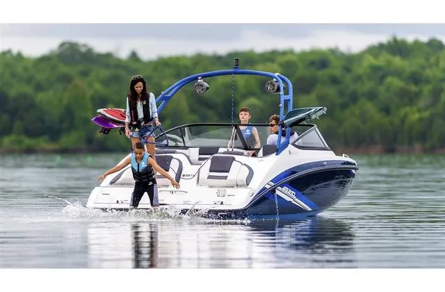 Slide: The Image of 2020 Yamaha AR210 boat with people enjoying water activities on a calm lake. - 29