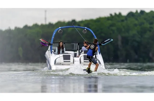 Slide: The Image of Wakeboarder behind 2020 Yamaha AR210 boat on a lake, surrounded by lush greenery. - 30