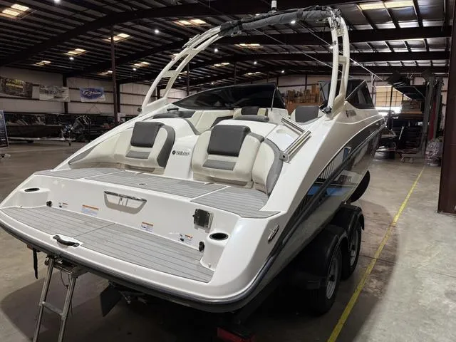 Slide: The Image of 2020 Yamaha AR210 boat in a warehouse, showcasing sleek design and dual seating. - 4