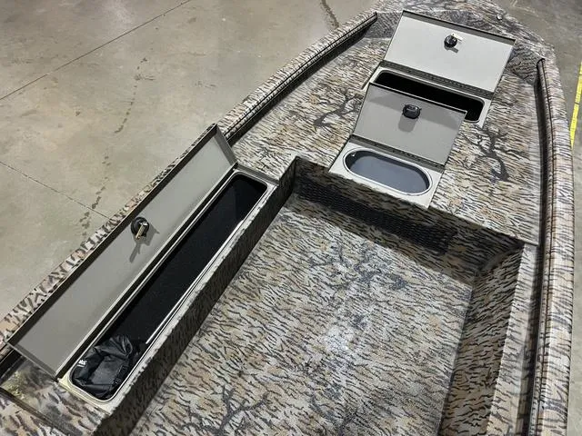 Slide: The Image of 2025 Xpress HD16DB boat interior with storage compartments and camo design. - 10