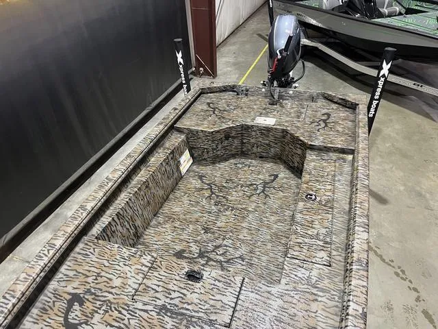 Slide: The Image of 2025 Xpress HD16DB boat with Yamaha 50 engine, camo design in a showroom. - 9