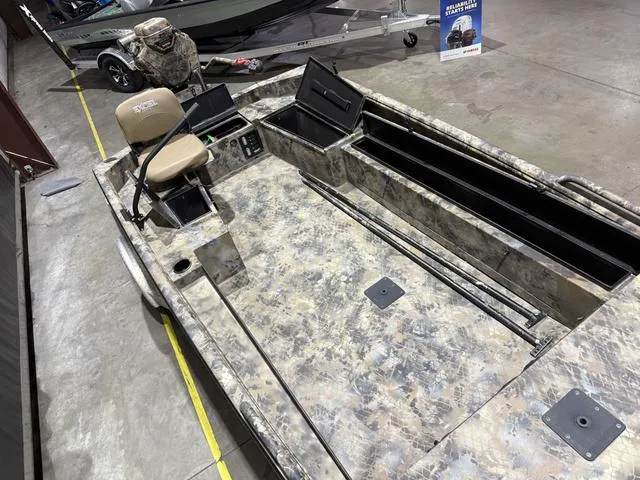 Slide: The Image of 2023 Excel Shallow Water F4 1860 boat with Mud Buddy 40HDR, camo design, displayed indoors. - 10