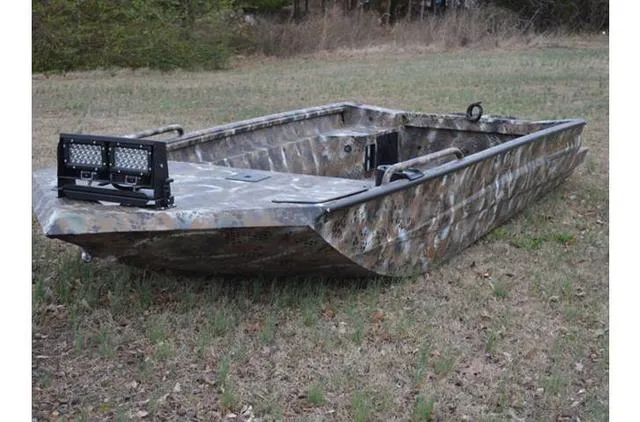 Slide: The Image of 2023 Excel Shallow Water F4 1860 boat with camo design on grassy field. - 25