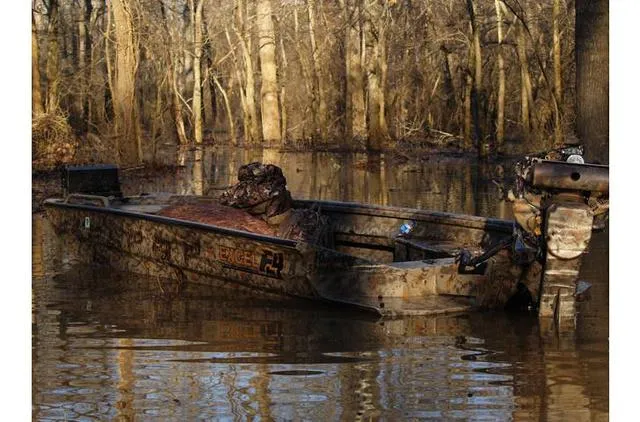 Slide: The Image of 2023 Excel Shallow Water F4 boat in a wooded, flooded area. - 33