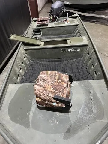 Slide: The Image of 2015 Alumacraft 1648 boat with Yamaha 25 engine, camo seats, and storage compartments. - 8