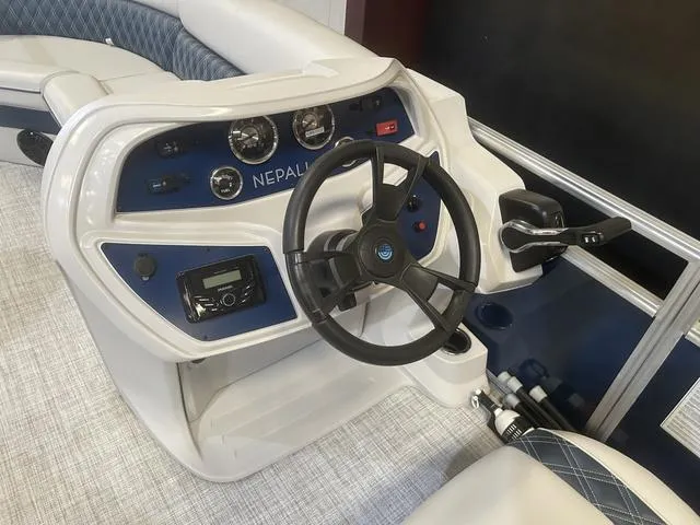 Slide: The Image of 2023 Nepallo Pontoons 22QL boat dashboard with steering wheel and controls. - 11