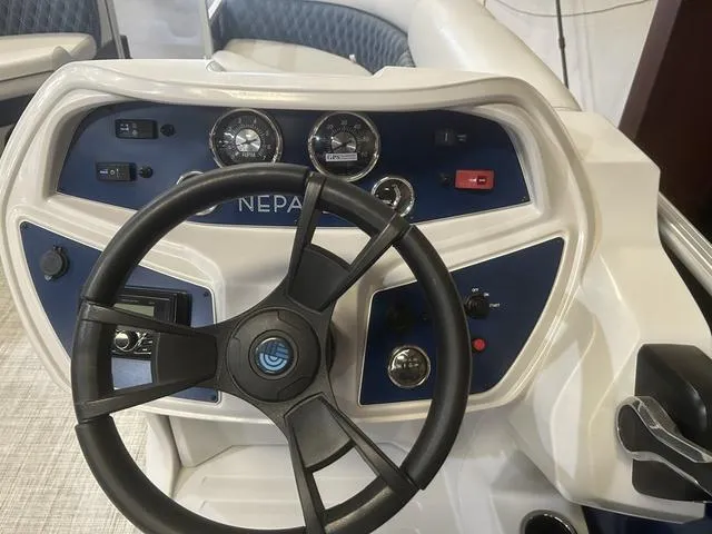 Slide: The Image of 2023 Nepallo Pontoons 22QL boat dashboard with steering wheel and control gauges. - 12
