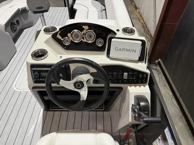 Slide: The Image of 2025 SunCatcher Select 322SS boat dashboard with Garmin navigation system and steering wheel. - 14