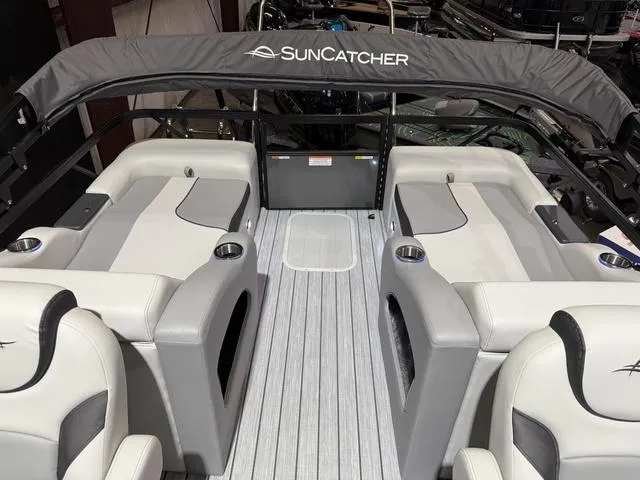Slide: The Image of 2025 SunCatcher Select 322SS boat interior with gray seating and SunCatcher logo canopy. - 16