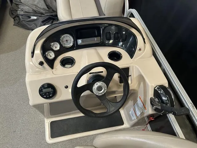 Slide: The Image of 2019 Sun Tracker PARTY BARGE 18 DLX boat dashboard with steering wheel and controls. - 12