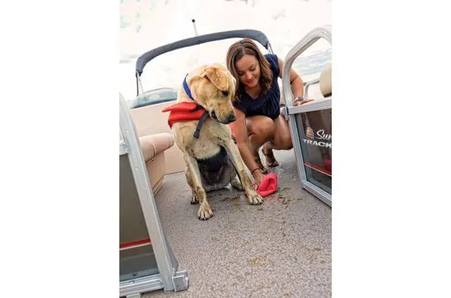 Slide: The Image of Woman and dog on 2019 Sun Tracker PARTY BARGE 18 DLX boat, cleaning the deck. - 29