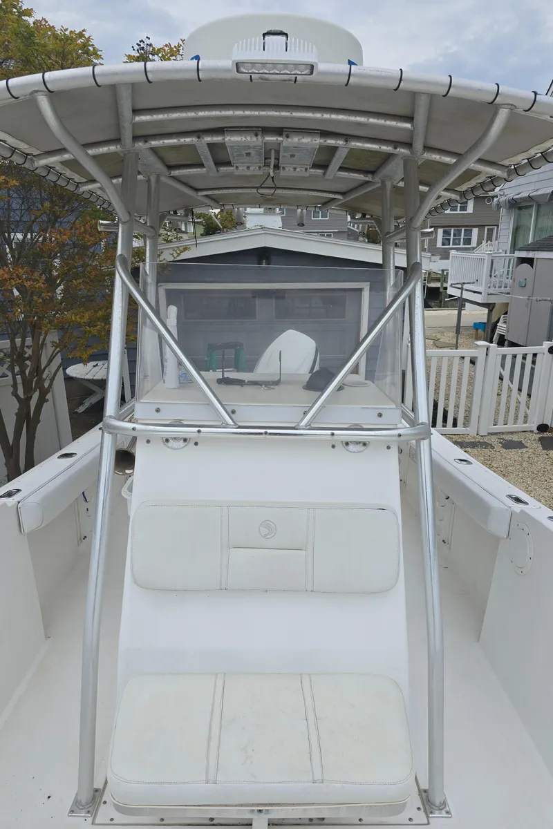 Slide: The Image of 2002 Edgewater 225CC boat on gravel, front view, with overcast sky. - 11