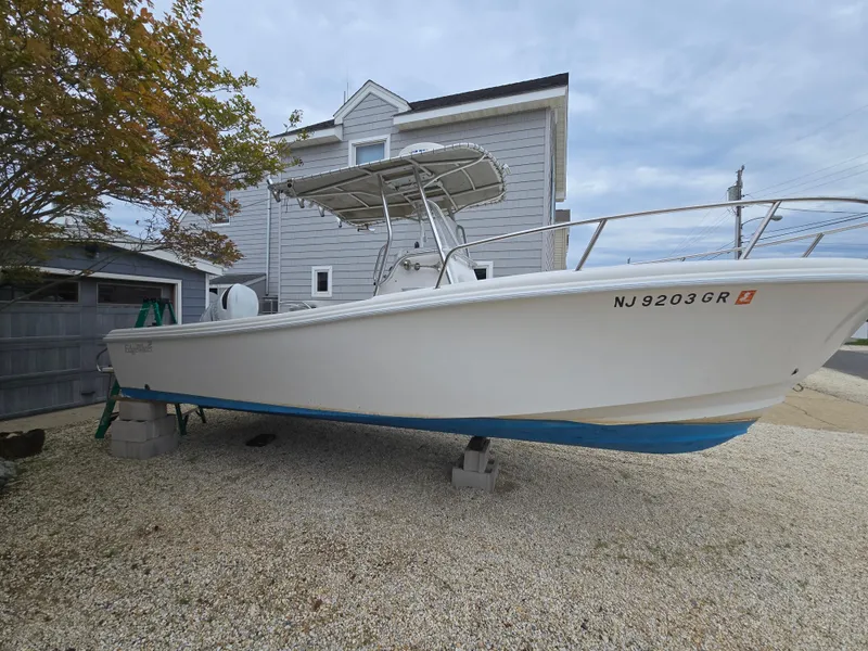 Slide: The Image of 2002 Edgewater 225CC boat interior with white seating and storage compartments. - 6